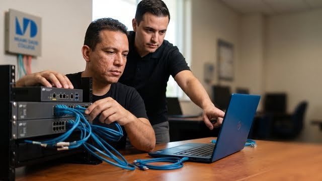 A student working with network cables and a laptop