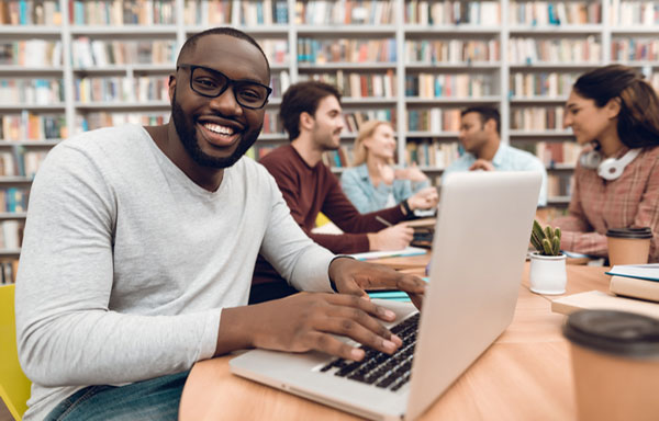 Male student typing in laptop