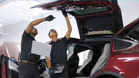 MDC Student and instructor inspecting a Tesla vehicle
